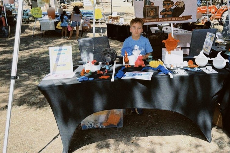 Joseph behind his market stall table, covered in 3D printed toys